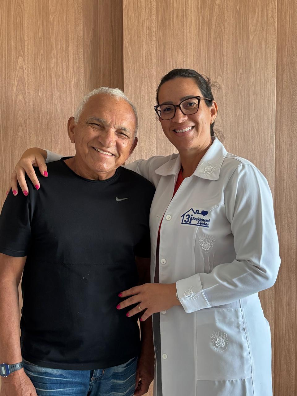 Profissional da 3i e idoso sorrindo juntos em casa, em Recife